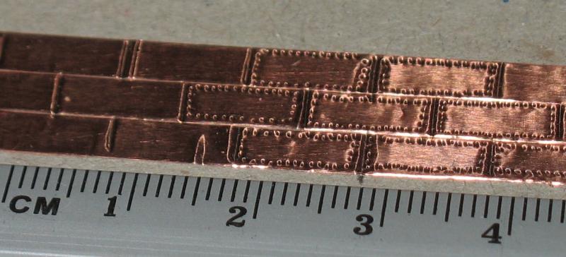 3 KoperenStrips van 4mm breed. Met potloodpunt (0,5 mm) onder vergrootglas puntjes in gedrukt als spijkerkop. Berekening: 0,5 x 84 = 42 mm. Zijn spijkerkoppen in het echt zo groot ?