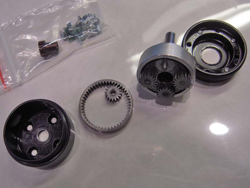 Anatomy part 1 AXI PG33 4:1 gearbox (1200W)

Links: planeethuis, cup, voor de tandkrans.
Linksmidden: tandkrans en 1 van de vier planeettandwieljes.
Rechtsmidden: planeet in lagerhuis met robuust lager 19 x 10 x X Vet lijkt me Molybdeenvet...
Rechts: planeethuis, cup, met 4 imbus stelschroeven om tandkrans en lagerhuis van de planeet als een sandwich samen te persen, zodat de tandkrans goed geborgd blijft zitten, zich niet los kan werken.

Het geheel ziet er uit als of het uit een Leica objectievenfabriek is gerold :)
