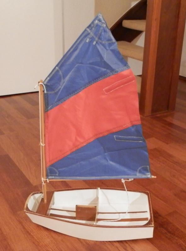 Optimist jeugdzelboot, het zeilmakerswerk begint er op te lijken maar nog niet helemaal tevreden, de giek komt wat te hoog uit en het achterlijk krult om, ook met zeillatten.